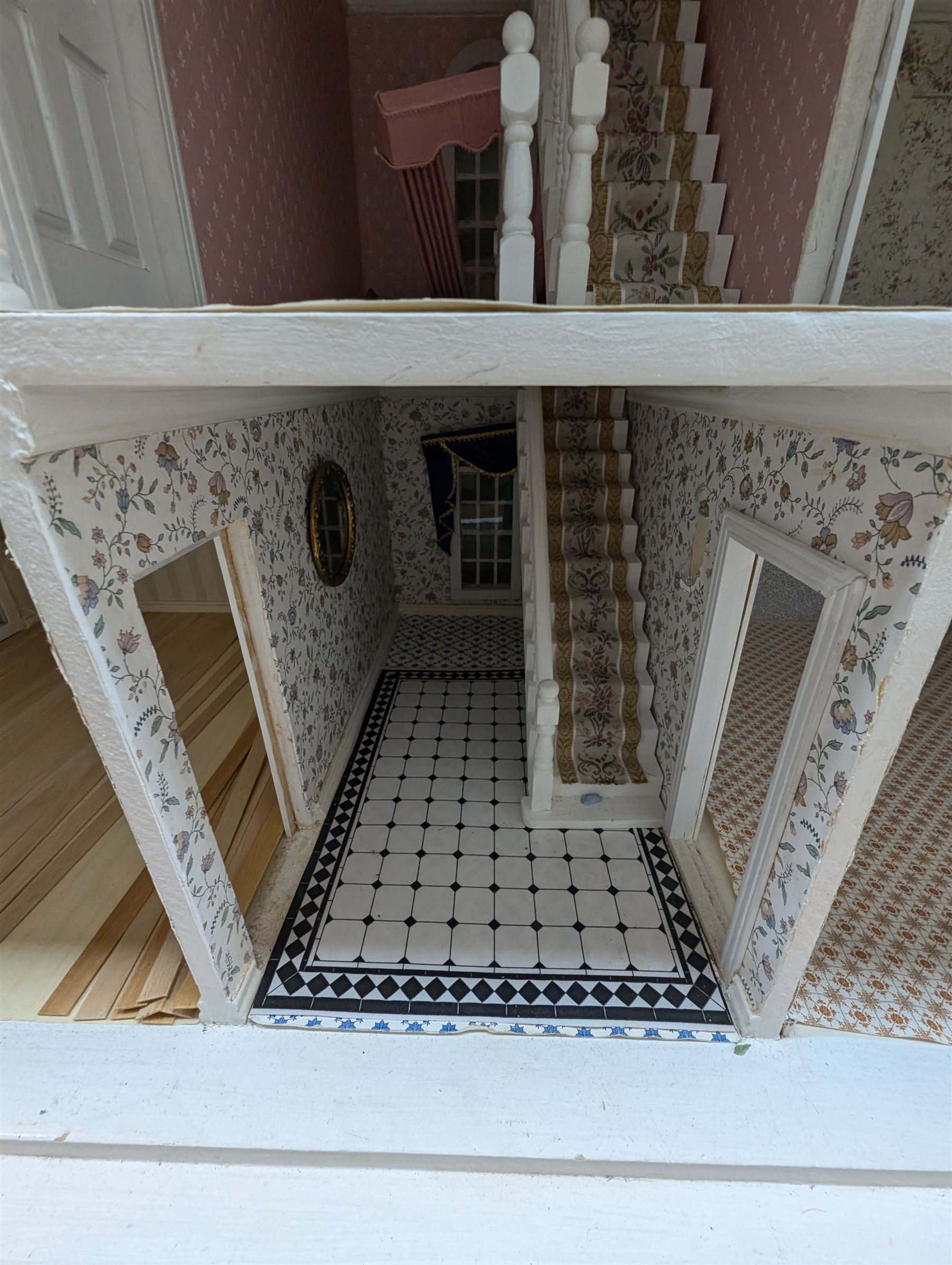 Large three storey modern dolls house, painted white with latticed windows, grey roof and metal fencing, with decorated interior, together with two dolls house garden rooms and two conservatories