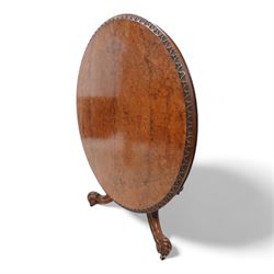 Victorian figured walnut breakfast or centre table, circular tilt-top with carved edge and quarter-matched veneers, turned pedestal with foliate carved baluster on three out splayed supports decorated with floral carvings and scrolled terminals, on brass castors 