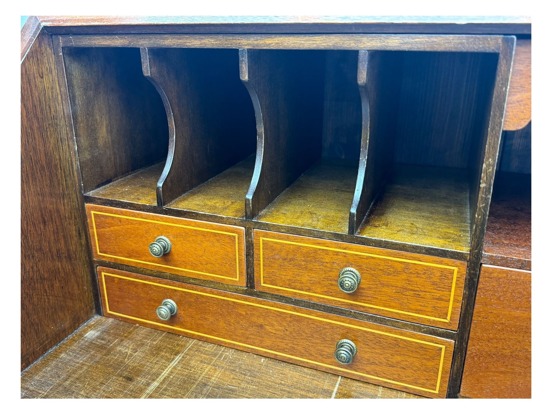 Mid-to-late 20th century inlaid mahogany bureau, inlaid floral medallion to the top, the fall front opening to reveal fitted interior with pigeonholes, small drawers and central cupboard, green inset writing surface with gilt tooling, four drawers below with brass handles, raised on shaped bracket feet