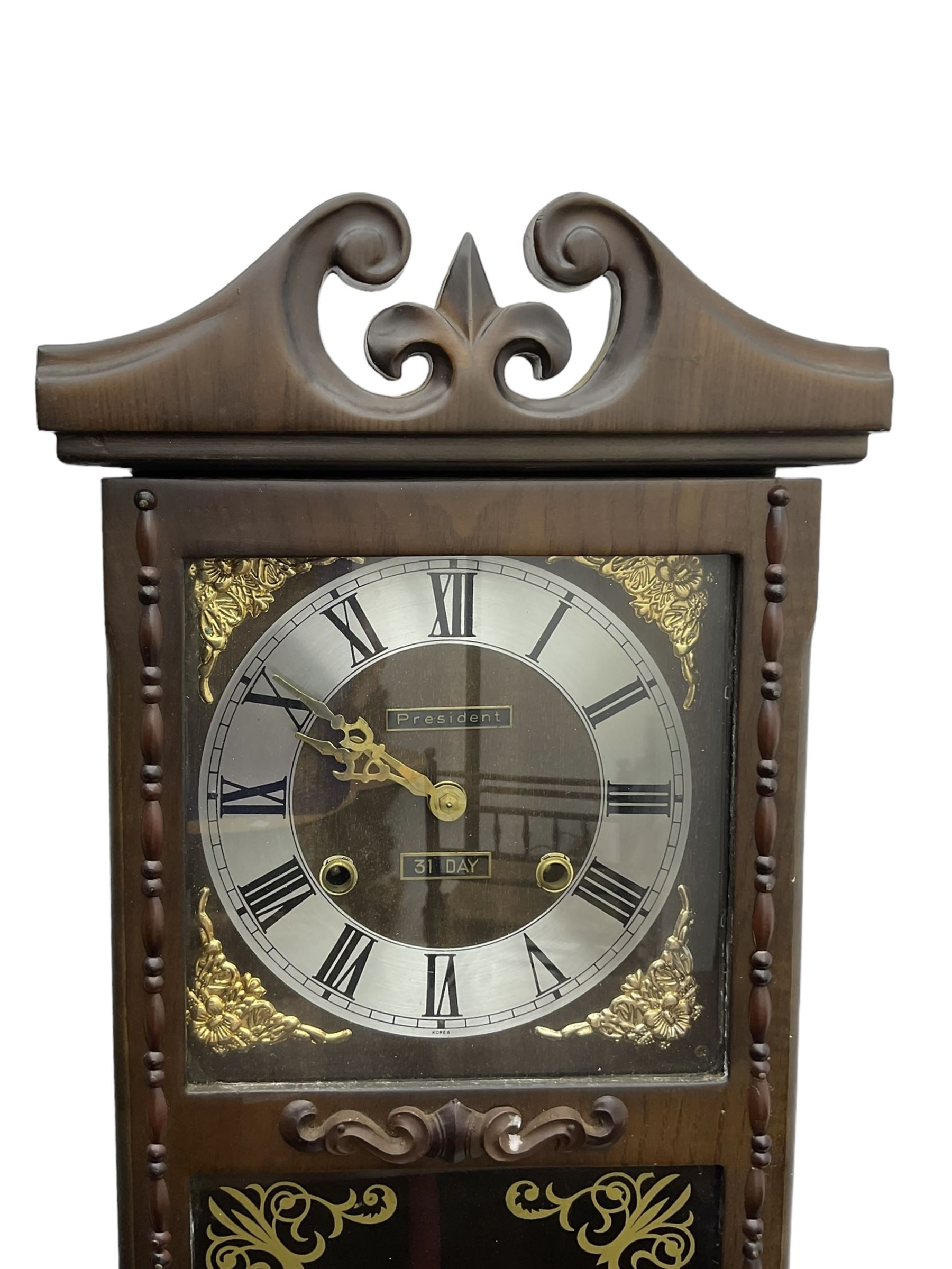 Month going twin train spring driven wall clock - in a glazed oak case with a swan necked pediment, silvered chapter ring with Roman numerals and gilt hands, with cast brass spandrels and a visible pendulum, striking movement, sounding the hours and half hours on a gong.