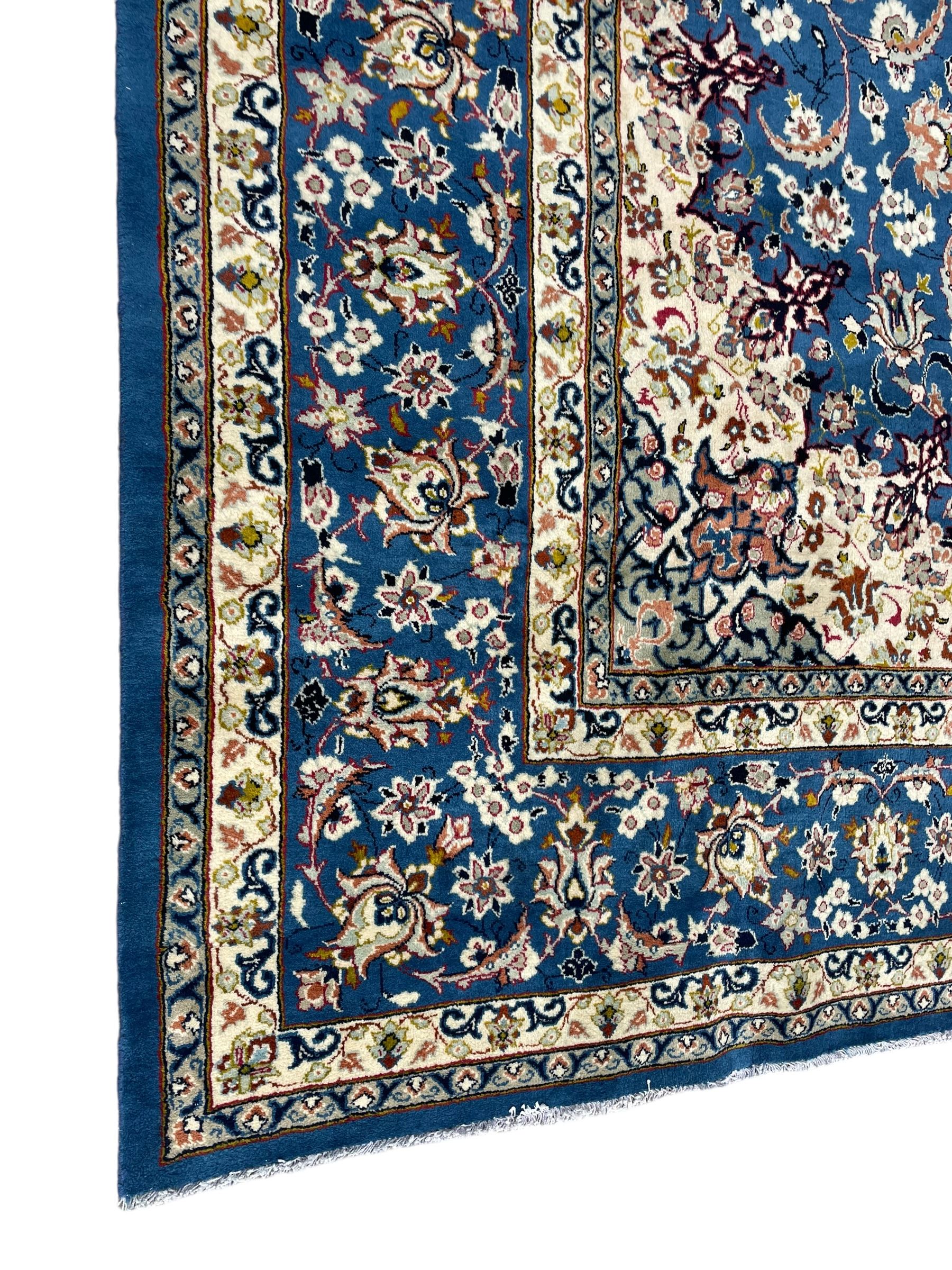 Persian Nain blue ground carpet, overall arabesque design, centre rosette medallion with eight projecting palmettes, the surrounding field decorated with interlacing branches and stylised plant motifs, within floral pale ground spandrels, the guarded border decorated with repeating stylised floral pattern 