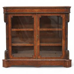 Victorian inlaid walnut and gilt metal mounted pier display cabinet, moulded rectangular top with extending square corners, the frieze inlaid with geometric satinwood bands and decorated with gilt metal edging, two glazed doors enclosing two shelves, enclosed by canted corners with recessed panels and gilt metal mounts, on moulded skirt base 