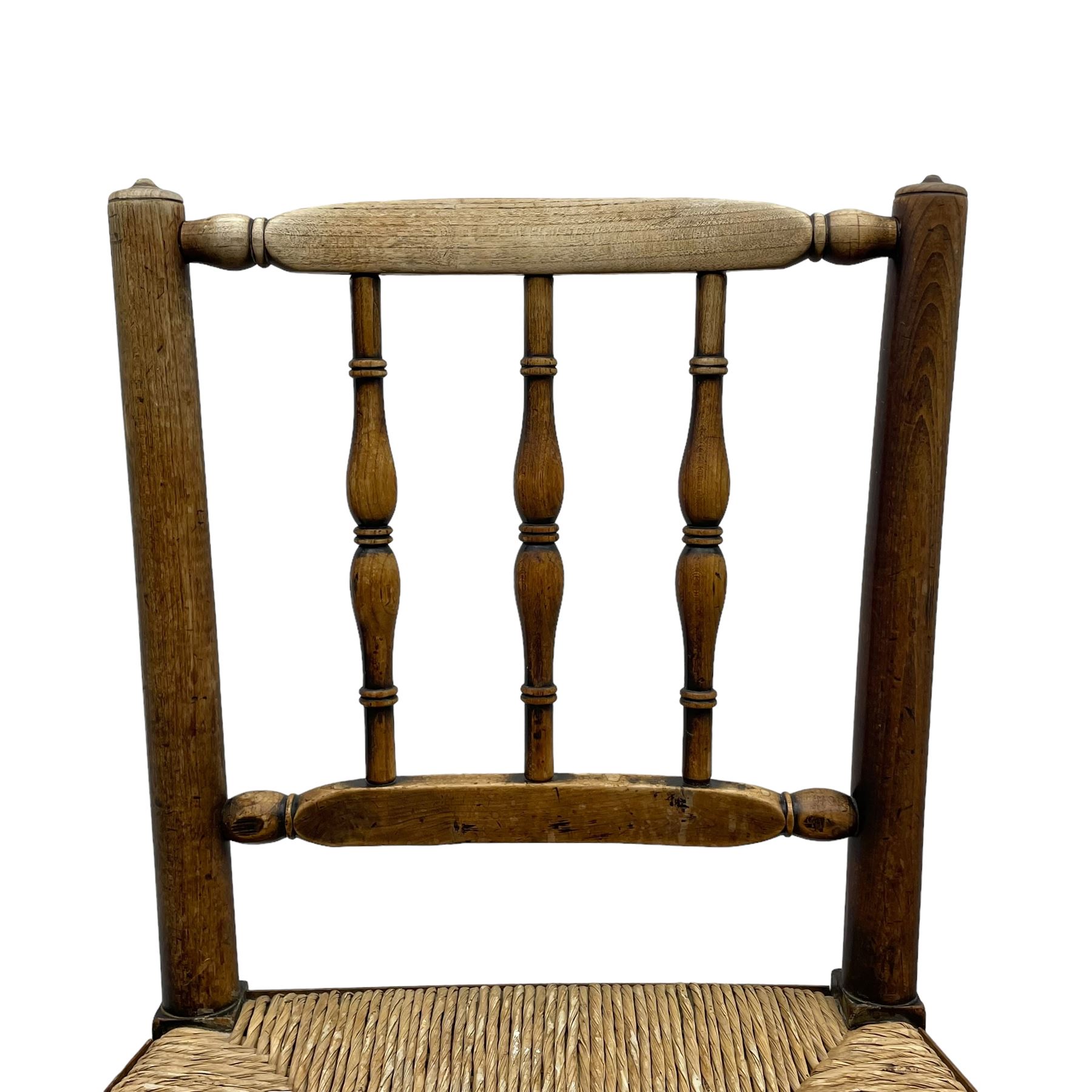 Set of four 19th century elm spindle back chairs, bar cresting rail over three turned vertical spindles, rush seat on turned supports united by turned stretchers 