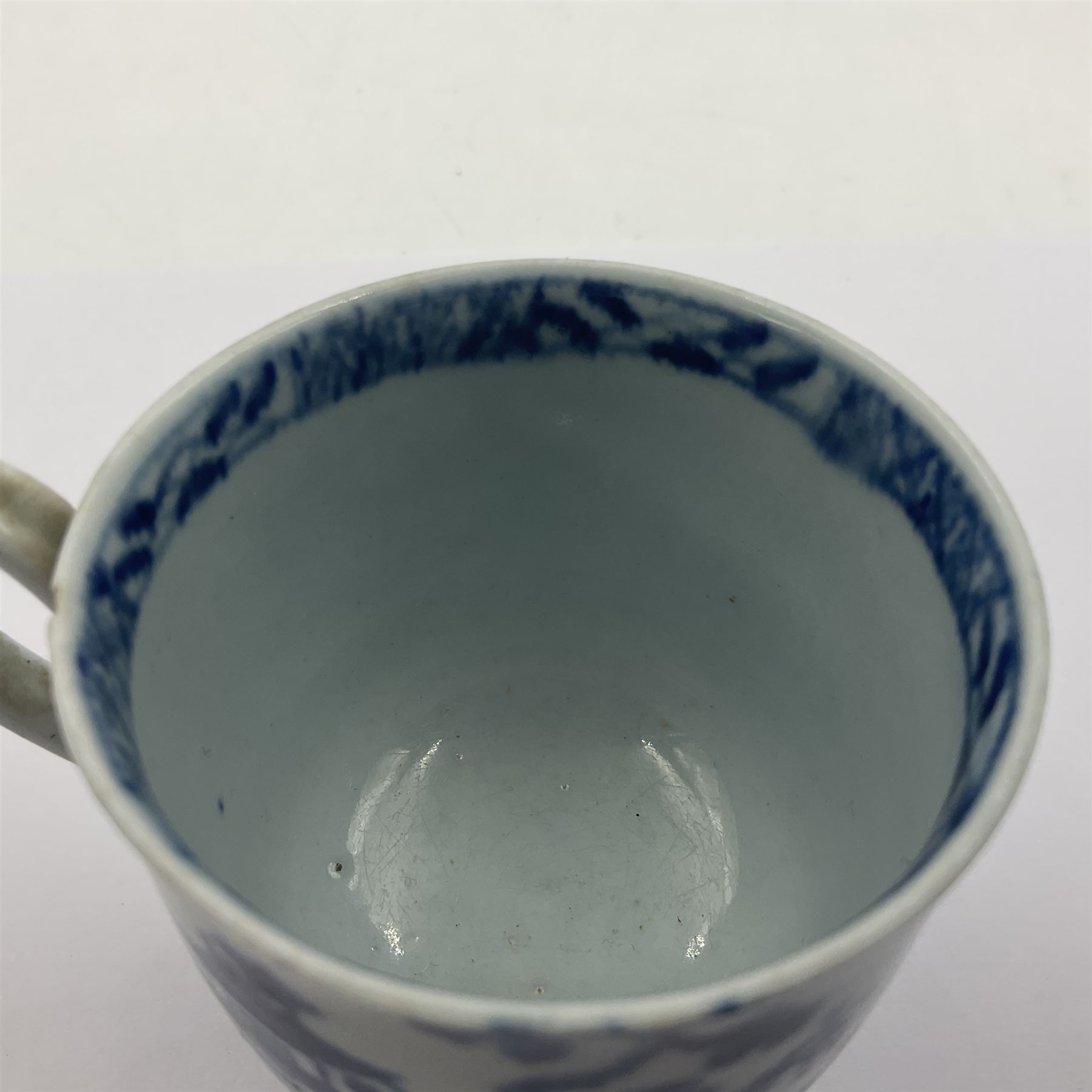 Two 18th century Worcester porcelain coffee cups, the first example decorated in the Plantation pattern, circa 1754, the second decorated in the Mansfield pattern, circa 1760, with workman's mark beneath, each approximately H5.5cm