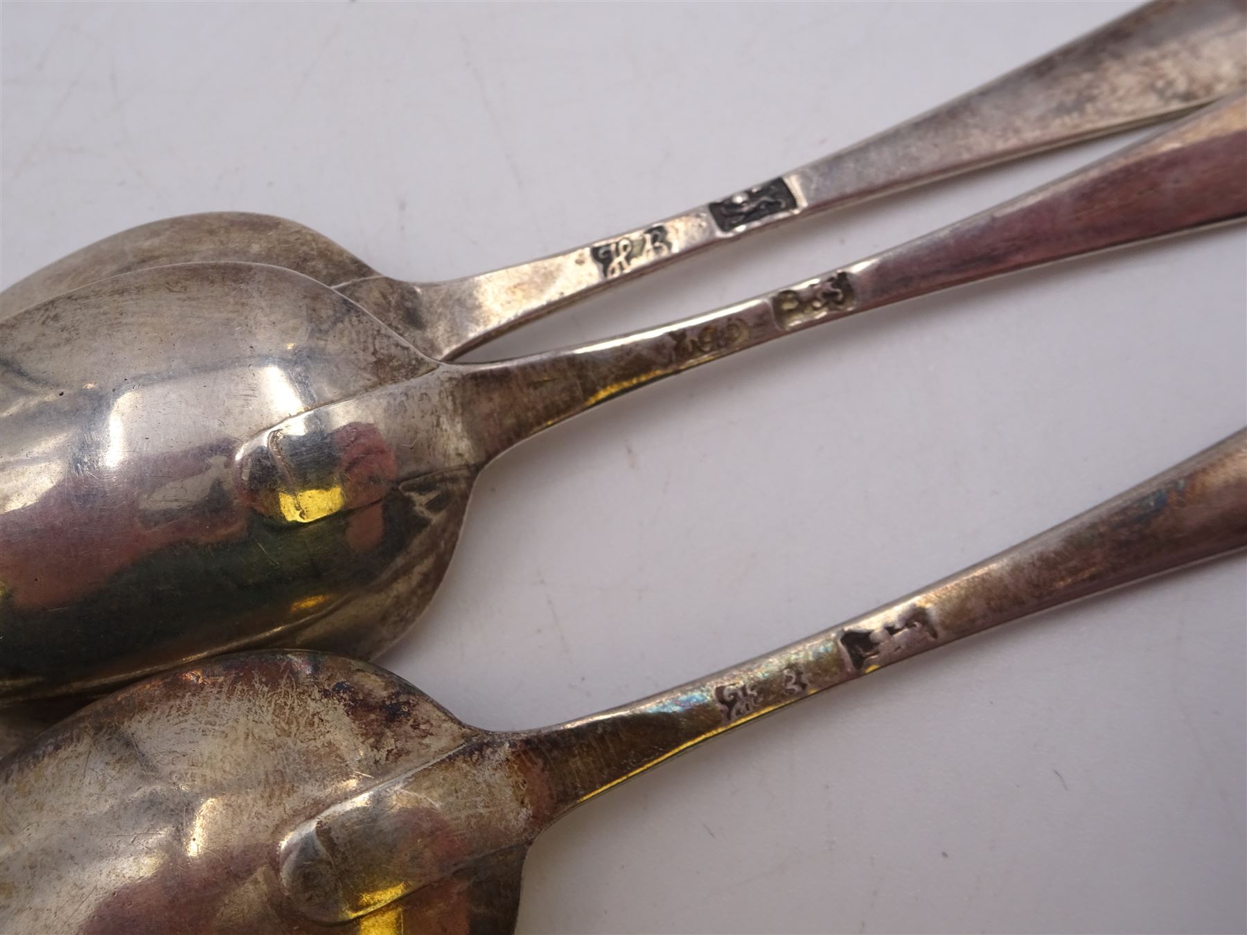 William IV Scottish silver thread and shell pattern spoon with later berry struck bowl, hallmarked William Russell II, Glasgow 1836, together with a George III silver Old English pattern dessert spoon, hallmarked William Davie, Edinburgh 1785 and a set of three Hester Bateman teaspoons with bottom struck hallmarks 