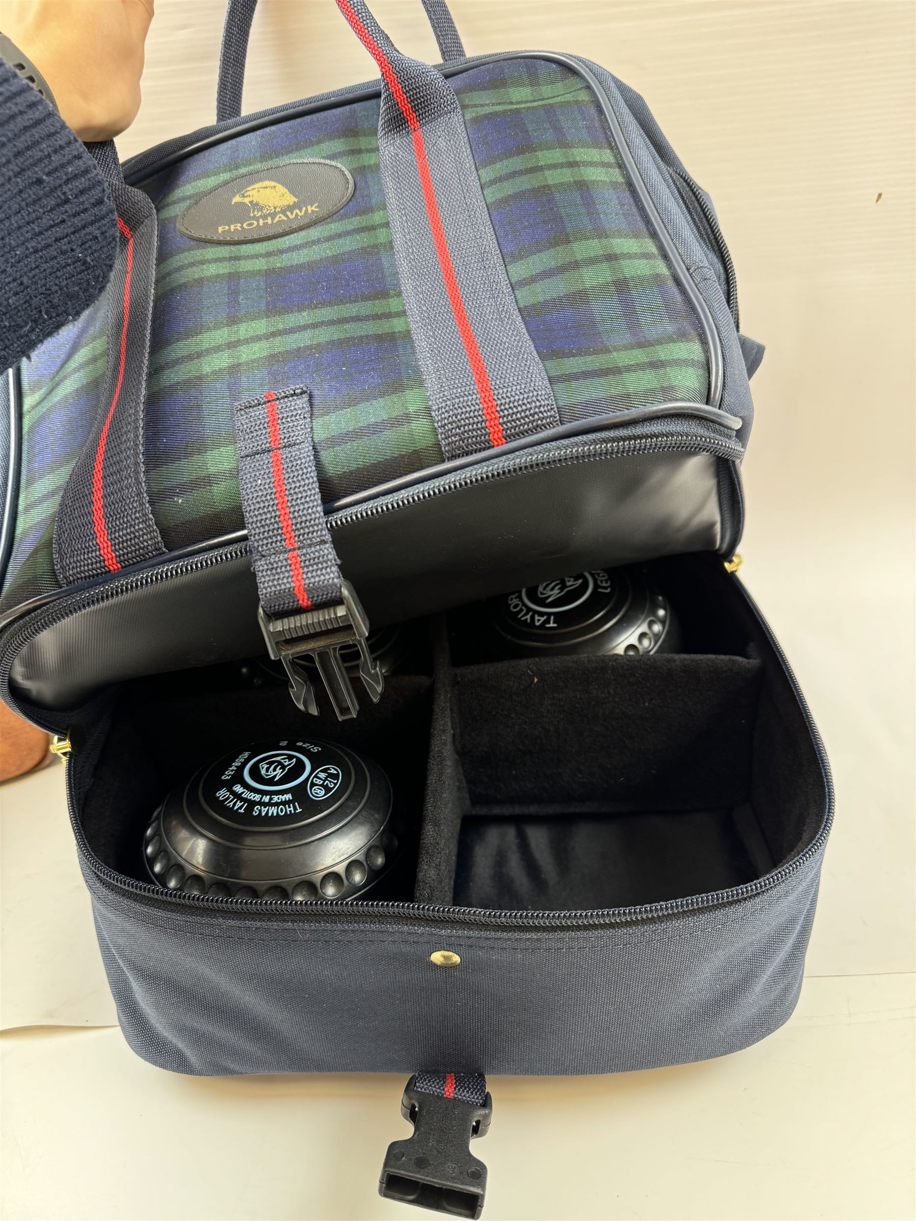 Two sets of flat green bowls, to include a ladies and gentlemans set, both contained within bowling bags