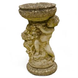 Composite stone garden bird bath, circular shallow bath on putto pedestal decorated with f...