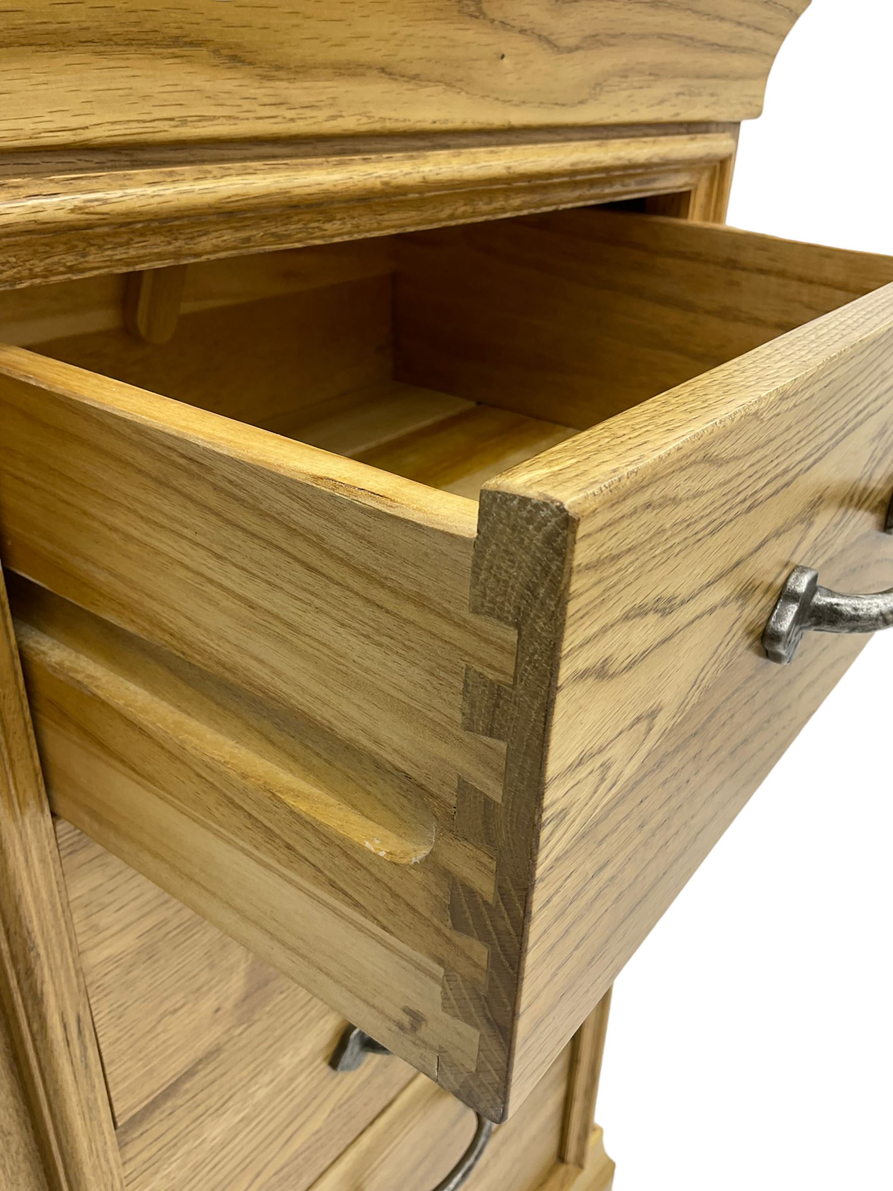 Contemporary light oak pedestal chest, moulded cornice and chamfered rectangular top with rounded fronts, over five drawers with metal handles and cock-beaded surrounds, on bracketed plinth base