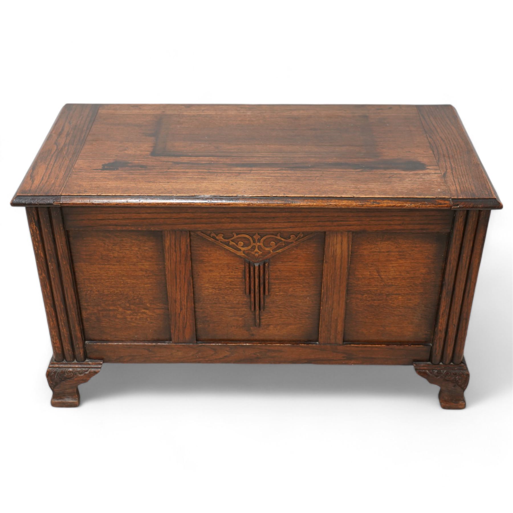 Early 20th century oak blanket chest, rectangular hinged top over triple panelled front with moulded decoration, on foliate carved ogee feet