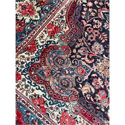 Persian Mahal indigo ground carpet, floral medallion on a field of swirling leafy branches and flower heads, shaped ivory field band decorated with flower head bouquets and trailing branches, the border decorated with floral motifs, within guard stripes