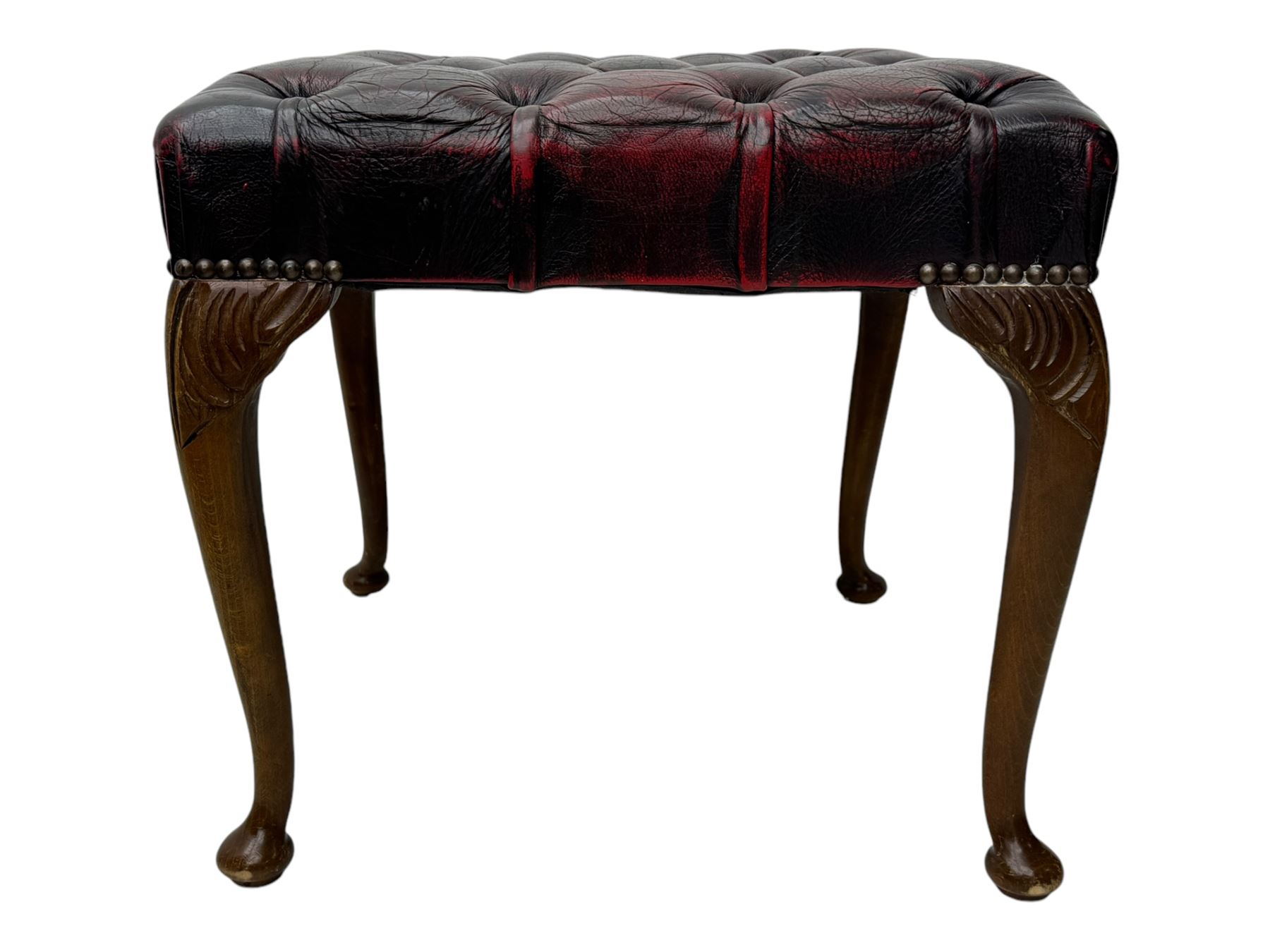 Chesterfield three-seat sofa, traditional shaped upholstered in deeply buttoned dark red leather; together with similar footstool 