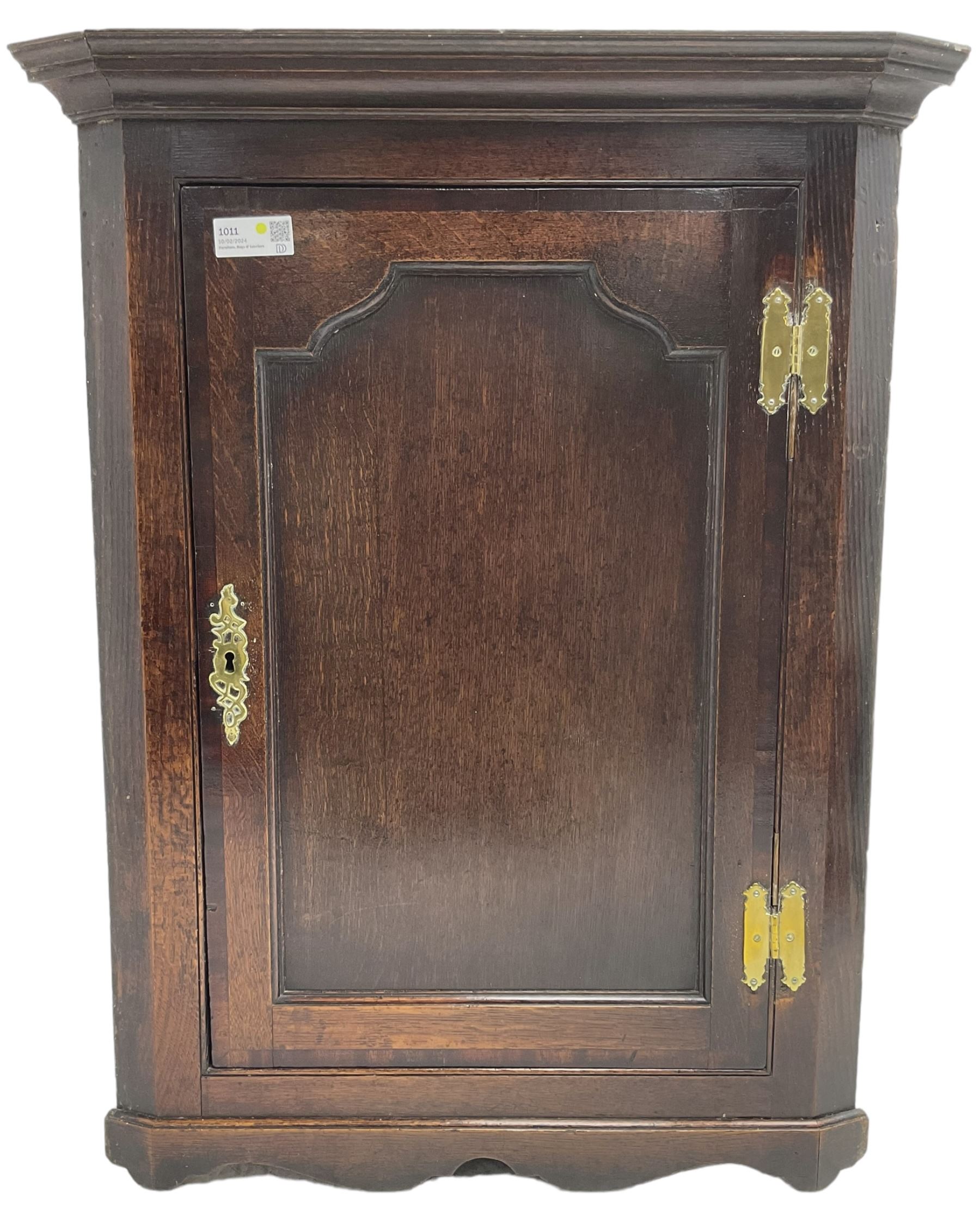 George III oak wall hanging corner cupboard, projected cornice over crossbanded and fielded panelled door, enclosing three shelves