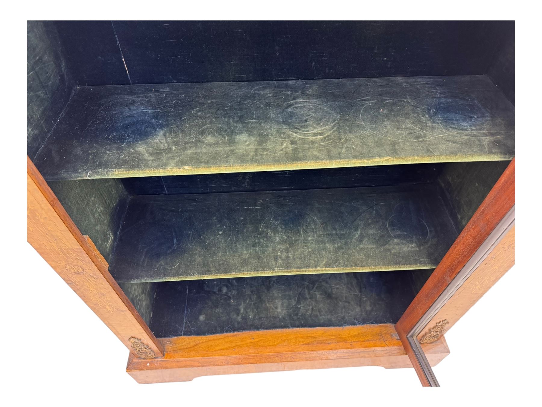 Late Victorian walnut pier cabinet, projecting cornice over frieze inlaid with foliate motifs, single glazed door flanked by ormolu mounts, enclosing shelved interior, on plinth base