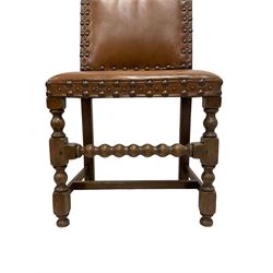 Set of six (4+2) early 20th century oak dining chairs, arched back and seat upholstered in tan leather with studwork detail, on turned supports united by bobbin-turned stretchers