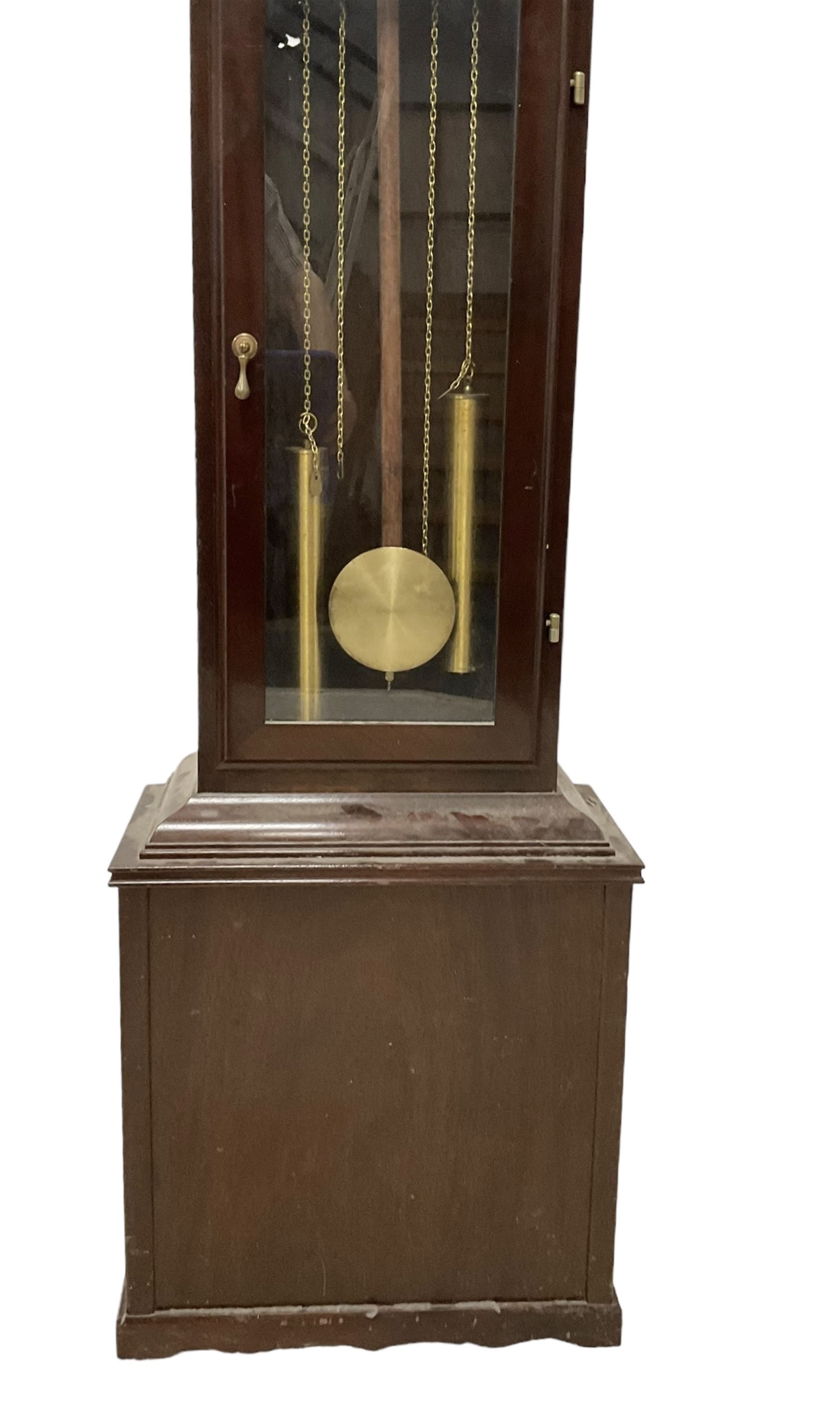 20th century - Westminster chime 8-day grandmother clock in a mahogany case, with a break arch top and brass finials, fully glazed trunk door with visible brass cased weights and pendulum, brass dial with etched dial centre and spandrels, chapter ring with Roman numerals and working moon disc to the arch, two train chain driven movement with 12 gong rods and chime selection for the quarters and hours.