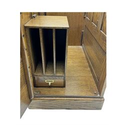 Early 20th century oak tambour roll-top desk, the top with fitted interior including drawers, pigeonholes and compartments, the twin pedestals fitted with four drawers with carved handles, supported by plinth base 