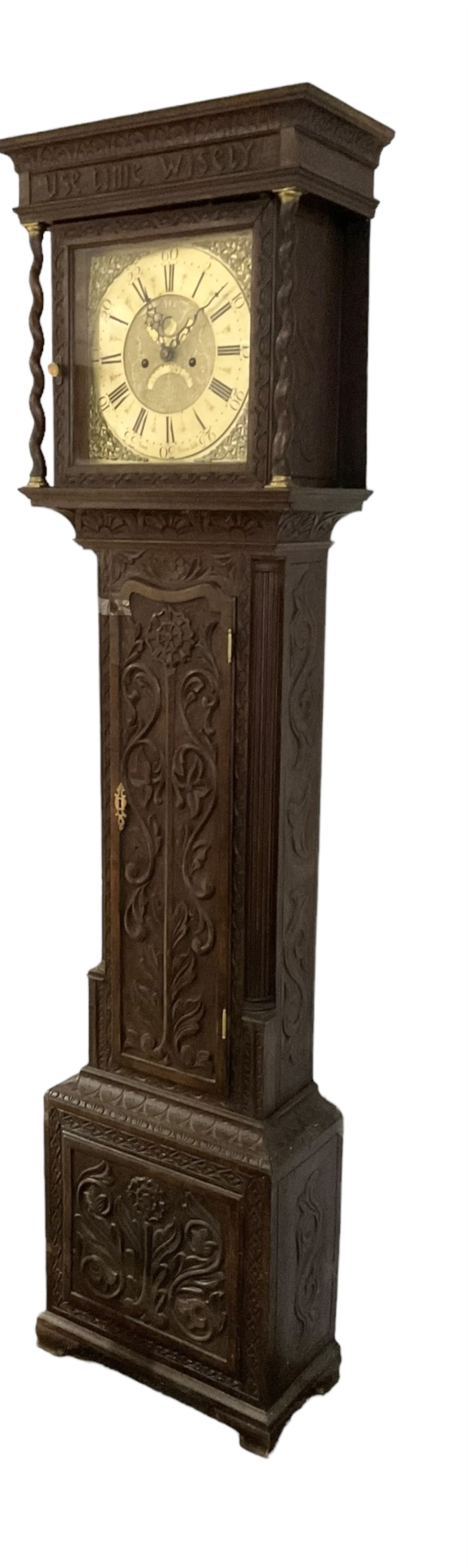 8-day - profusely carved oak longcase, with a flat top and square hood door beneath, door flanked by barley twist columns with brass capitals, trunk with reeded quarter columns and wavy topped door, on a carved plinth raised on bracket feet, brass dial with an engraved and matted dial centre, penny moon and date aperture, chapter ring inscribed “John Stancliffe” with Roman numerals and five-minute Arabic's, rack striking movement with a recoil anchor escapement. With pendulum and weights.