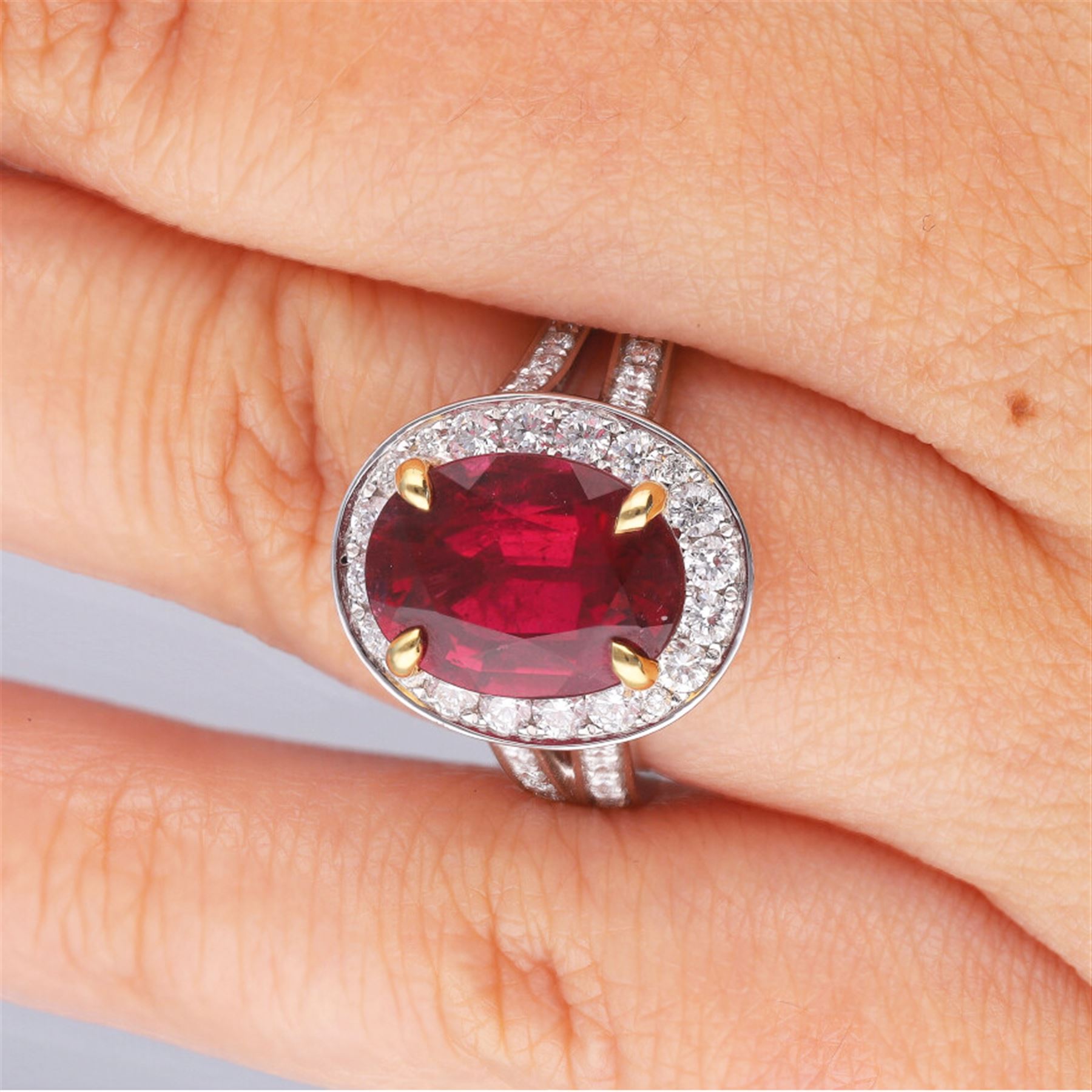 18ct white gold oval cut rubellite tourmaline and round brilliant cut diamond cluster ring, with diamond set shoulders, hallmarked, rubellite 3.93 carat, total diamond weight 0.86 carat 