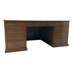 Large 20th century oak twin pedestal desk, moulded rectangular top over nine drawers, panelled pedestals, on moulded plinth base 