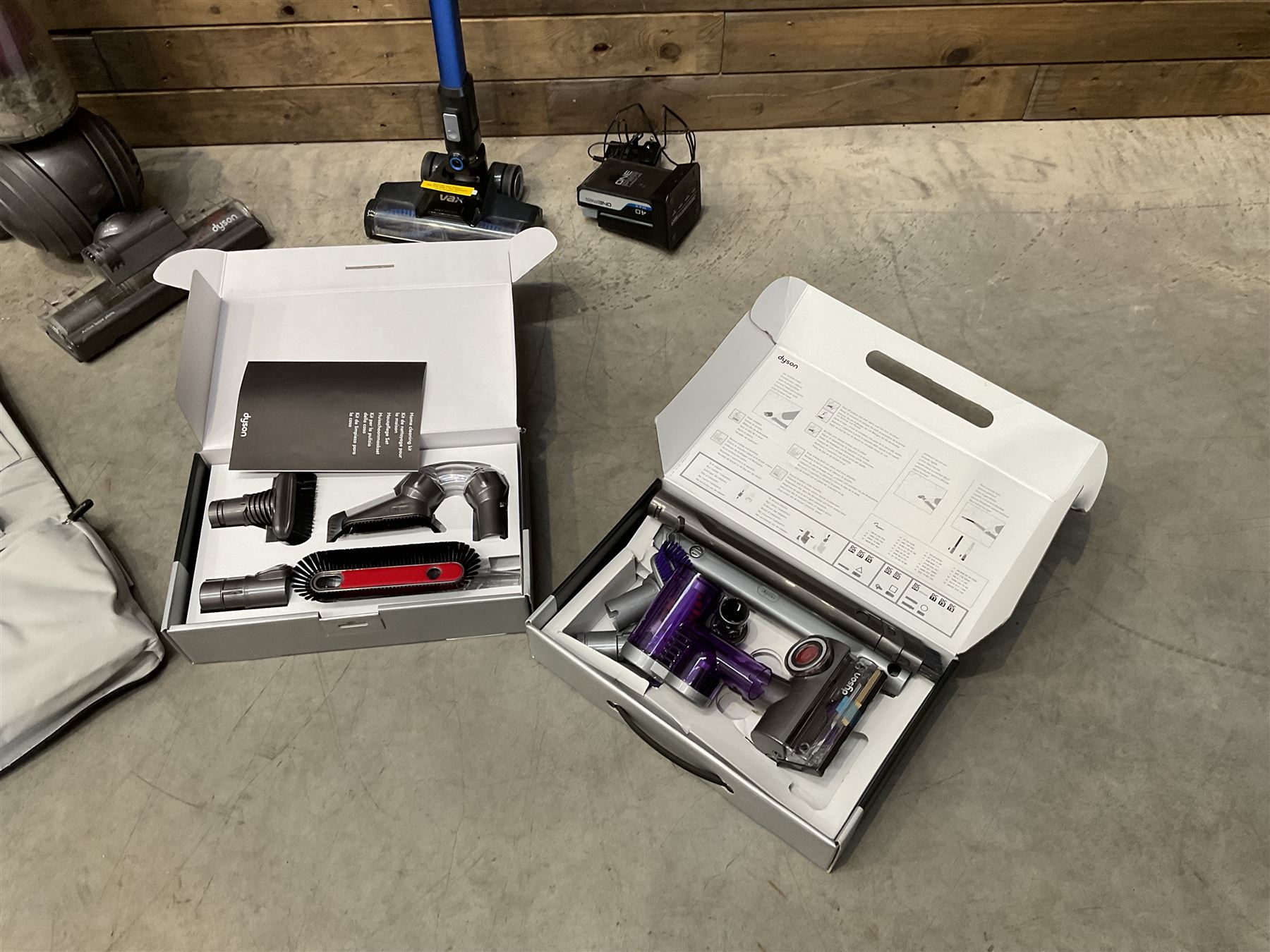 Dyson DC40 vacuum cleaner with various attachments, and a Vax cordless vacuum cleaner with single battery and charger