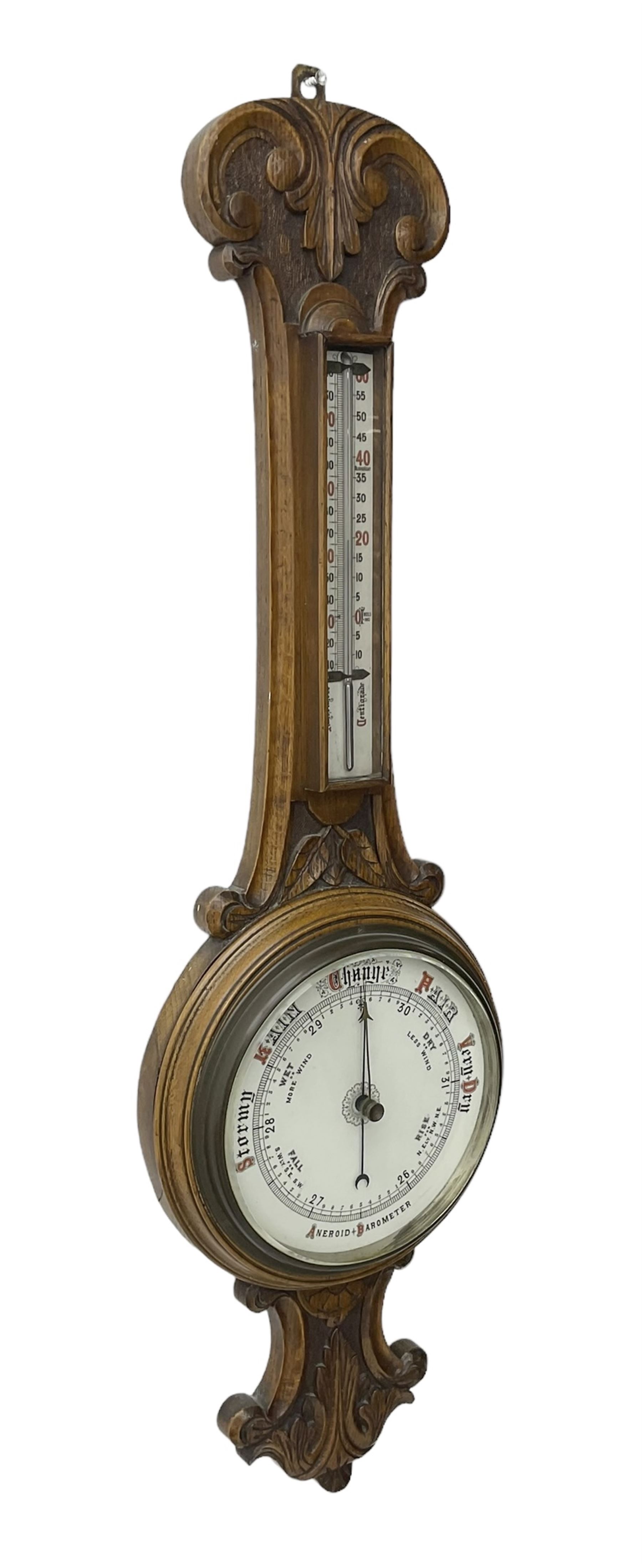 Edwardian - carved oak aneroid barometer, with a rounded top carved with scroll work, 8