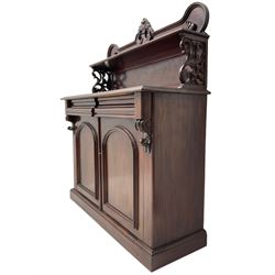 Victorian mahogany chiffonier, raised shaped back with foliage scroll carved mounts, on fretwork and carved bracket supports, moulded rectangular top over two frieze drawers and double panelled cupboard, on moulded plinth base