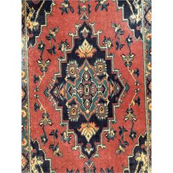 Northwest Persian salmon ground runner, the field decorated with a series of geometric medallions, surrounded by a multi-band border with floral motifs