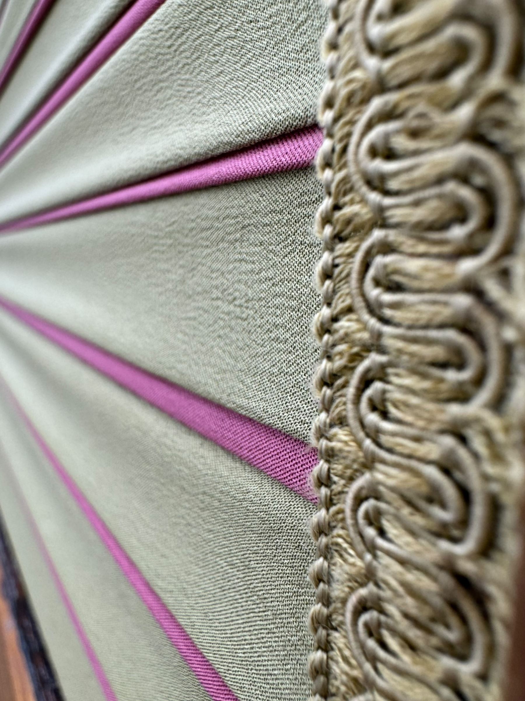 Edwardian oak and fabric folding screen, featuring three panels with oak frames, one side covered in green striped fabric with decorative trim, the reverse side in pink moiré effect fabric, connected by brass hinges