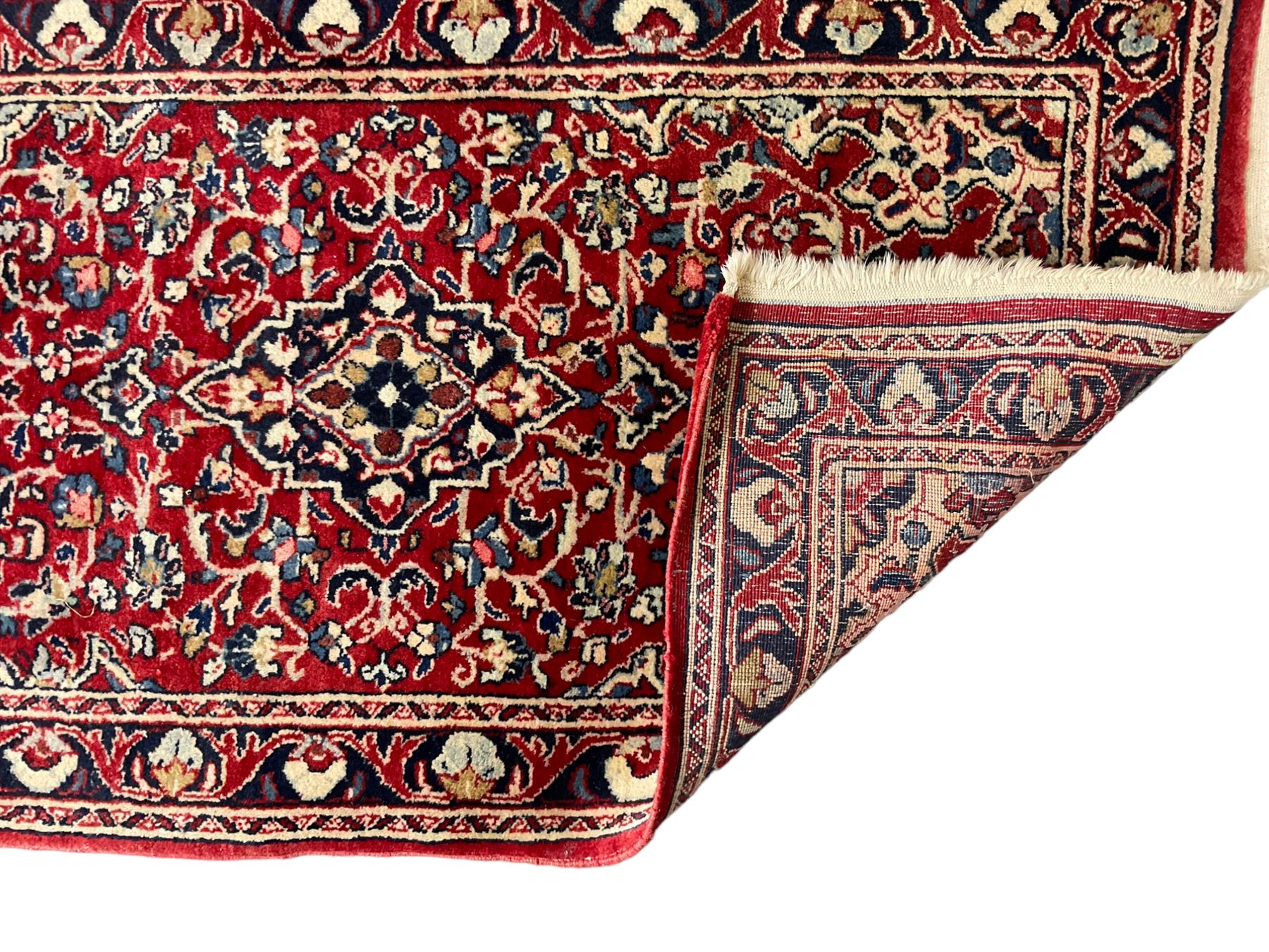 Persian crimson ground rug or mat, field decorated with central medallion and all-over scrolling floral motifs, border with repeating palmettes