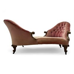 Victorian walnut framed tete-a-tete loveseat, scrolled arm terminals with moulded foliate decoration, buttoned backs and sprung seat upholstered in pale pink velvet, raised on cabriole supports with applied flower heads and scroll feet terminating to ceramic castors