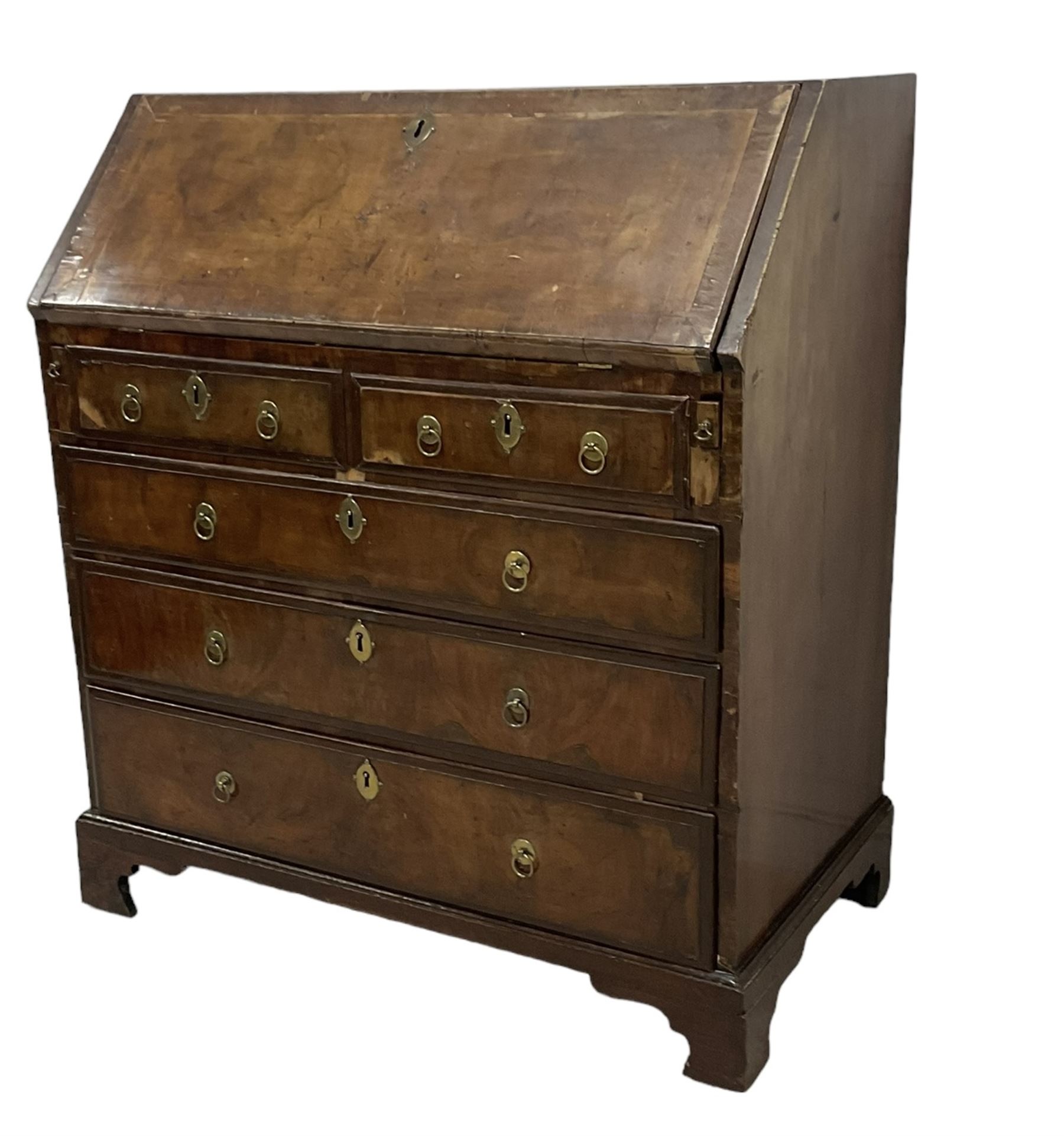 18th century walnut bureau, crossbanded and feather-banded rectangular top and fall-front, enclosing fitted interior with pigeonholes and correspondence drawers with bone handles, over two short and three long graduating drawers with moulded facias and original brass handles, on bracket feet