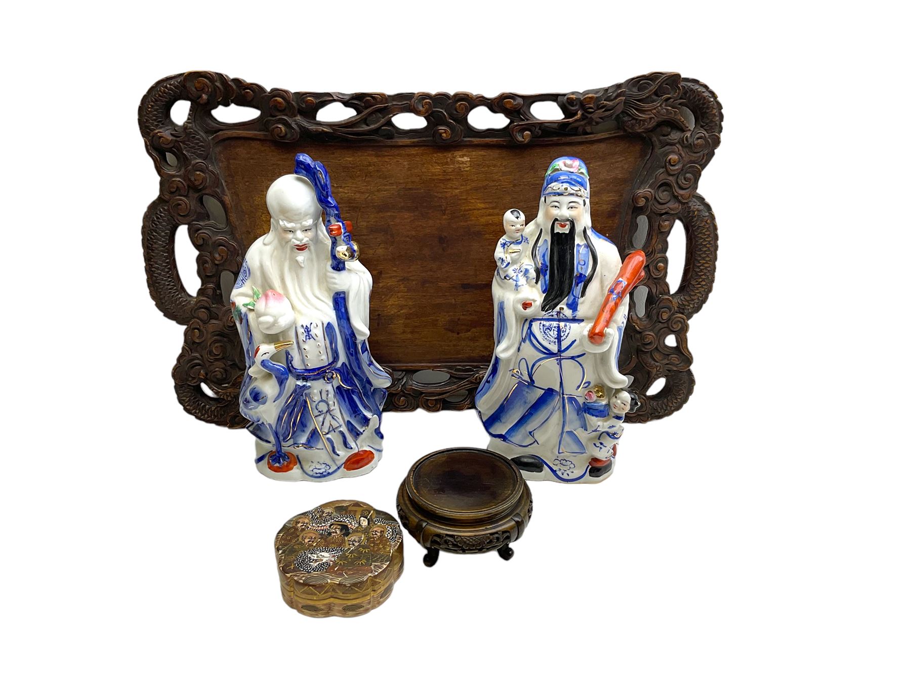 Chinese carved wooden tray, the rim carved as two dragons amidst clouds, D58.6cm, together with two Chinese blue and white Fu Lu Shou figures, each modelled as a sage, H30.5cm, a Japanese Satsuma box and cover, D10.5cm, and a small Chinese carved wooden stand, H6cm top D9.5cm