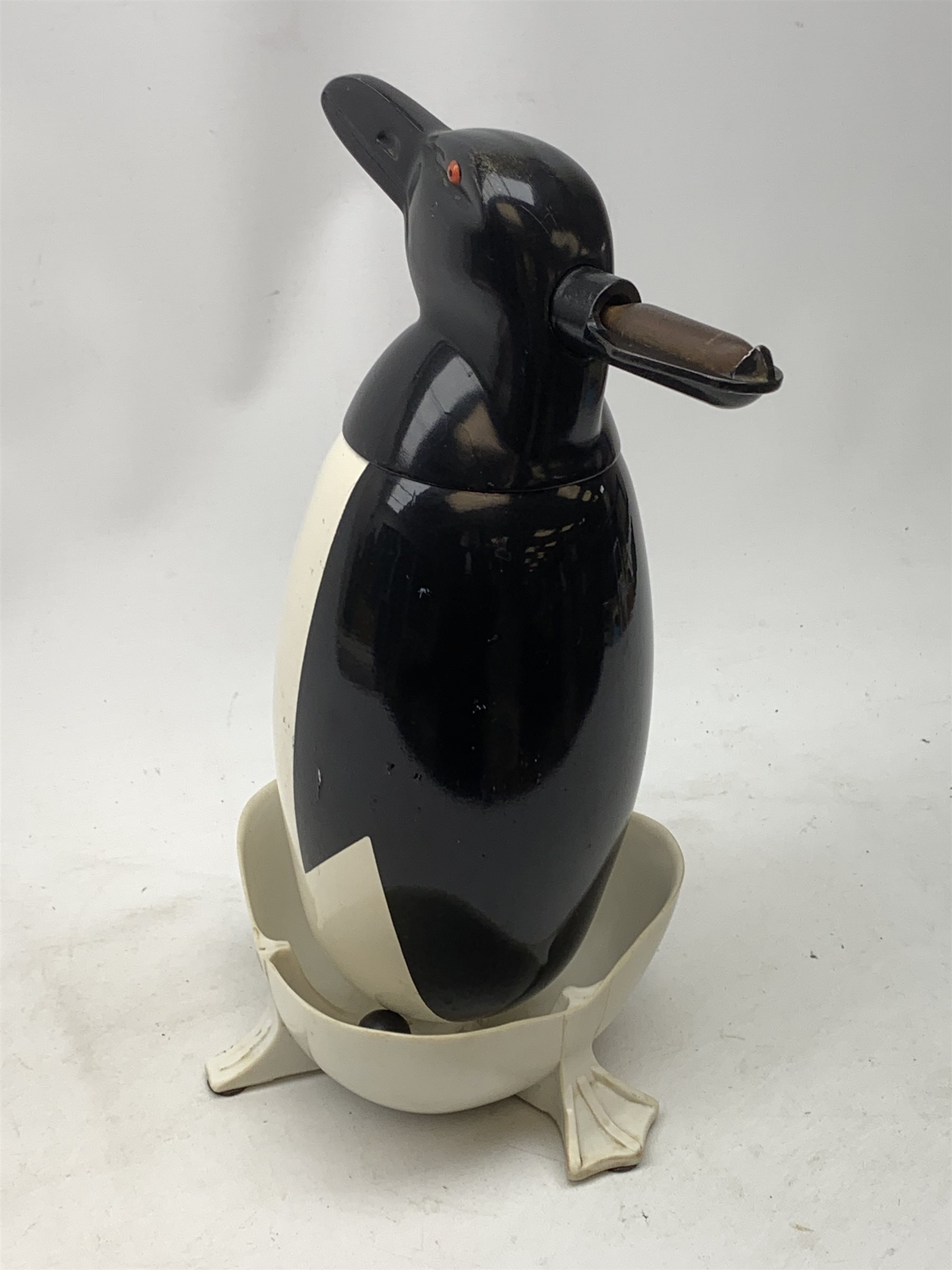 A Russian Soviet period soda siphon, modelled as an enamel penguin, and raised upon a plastic drip tray, H35.5cm 