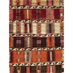 Southwest Persian Qashqai Kilim ground rug, featuring a series of horizontal striped panels each filled with intricate geometric designs, enclosed by a dark blue and ivory border with stylised star and zigzag motifs