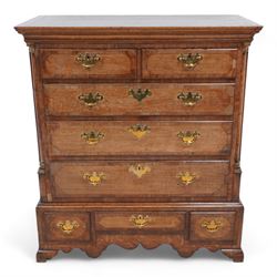 George III oak and mahogany banded chest on stand, moulded cornice over two short and three long drawers, shaped brass handle plates and swan neck handles, enclosed by canted corners with turned quarter columns, the stand fitted with three drawers, on bracket feet