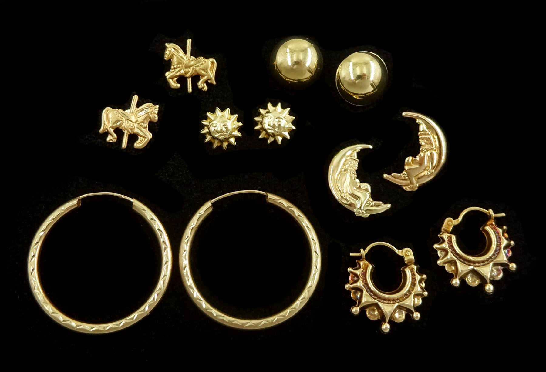 Five pairs of 9ct gold stud earrings including hoops, sun and crescent moon and a pair of 14ct gold carousel horse stud earrings