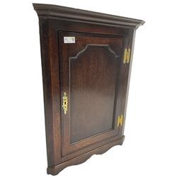 George III oak wall hanging corner cupboard, projected cornice over crossbanded and fielded panelled door, enclosing three shelves