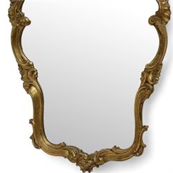 Ornate gilt framed wall mirror, shell pediment over scrolled foliate frame enclosing plain mirror plate