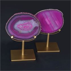 Pair of pink agate slices, polished with rough edges, raised upon gilt metal stands, H20cm