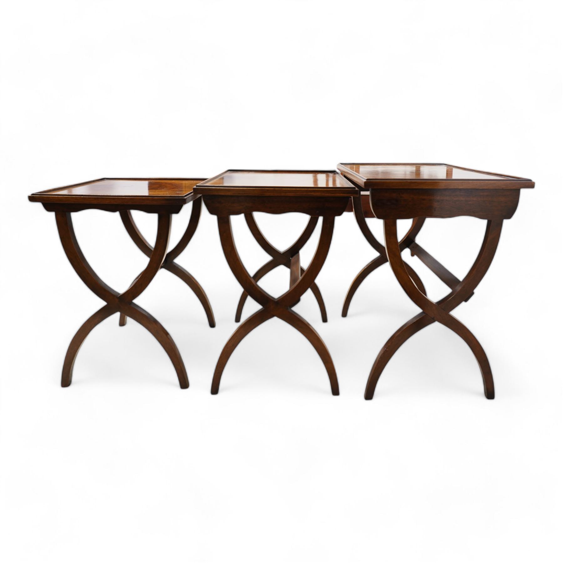 Regency design mahogany nest of three tables, rectangular top with raised lip on curved X-frame supports united by turned stretchers 