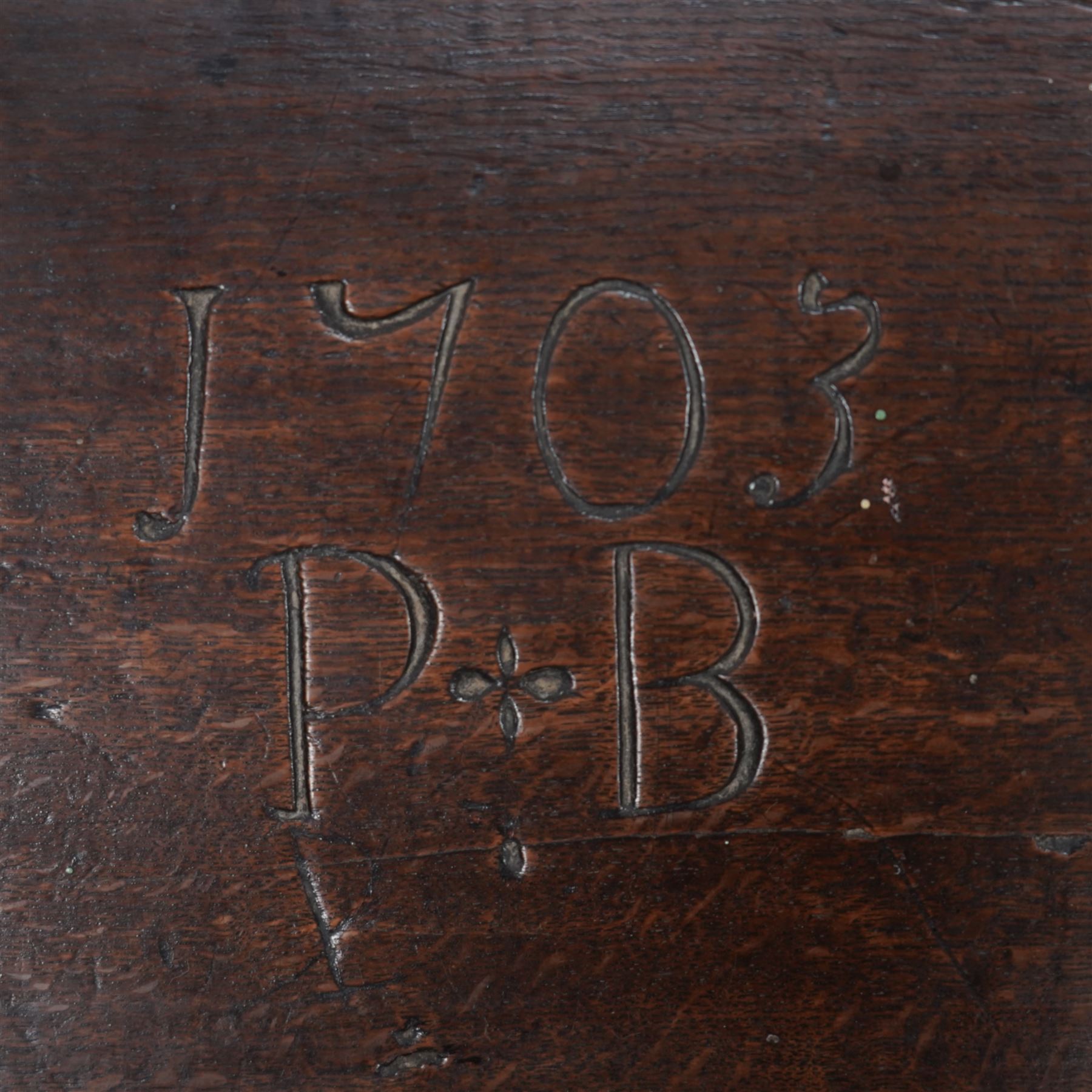 Early 18th century oak bible box, sloped hinged lid inscribed '1703 P.B', the front and sides carved with foliate scroll bands