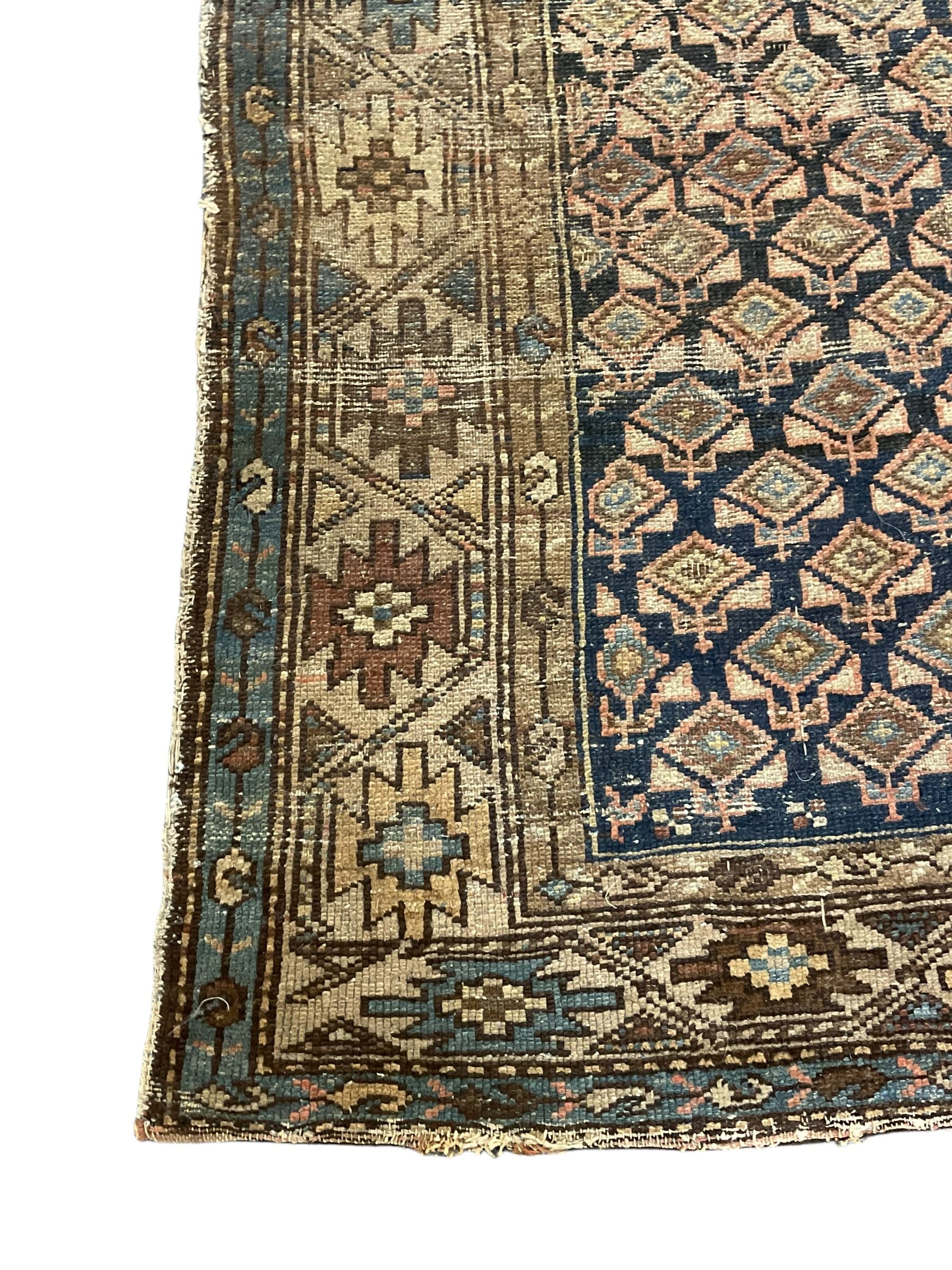 Caucasian indigo ground rug, the field decorated with geometric motifs within geometric pattern borders 