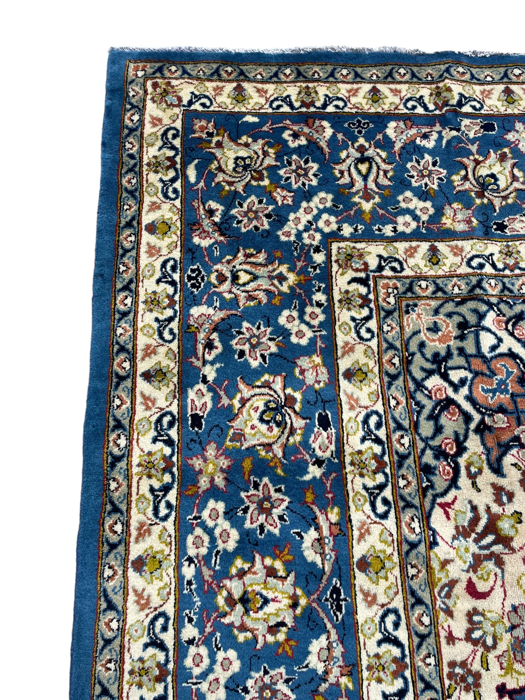 Persian Nain blue ground carpet, overall arabesque design, centre rosette medallion with eight projecting palmettes, the surrounding field decorated with interlacing branches and stylised plant motifs, within floral pale ground spandrels, the guarded border decorated with repeating stylised floral pattern 