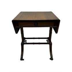 Mahogany drop-leaf sofa table, rectangular top over single frieze drawer with carved rosette handle, twin turned columns united by twin stretchers, on splayed supports terminating in paw feet with castors