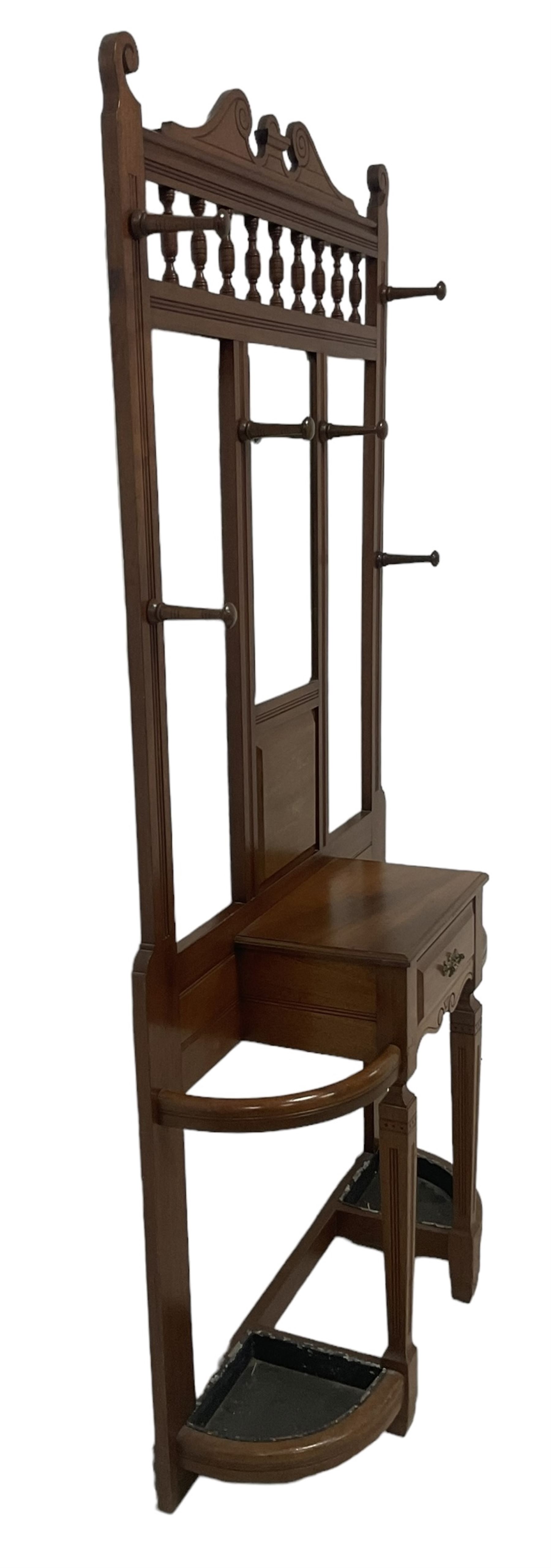 Late Victorian hallstand, raised pediment over balustrade frieze, bevelled mirror back with coat hooks over glove drawer, fitted with two drip-trays to base