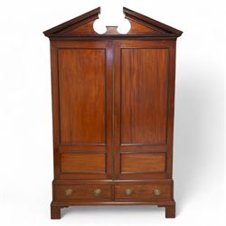 George III mahogany wardrobe, broken sloped arch pediment over two panelled doors, the bas...