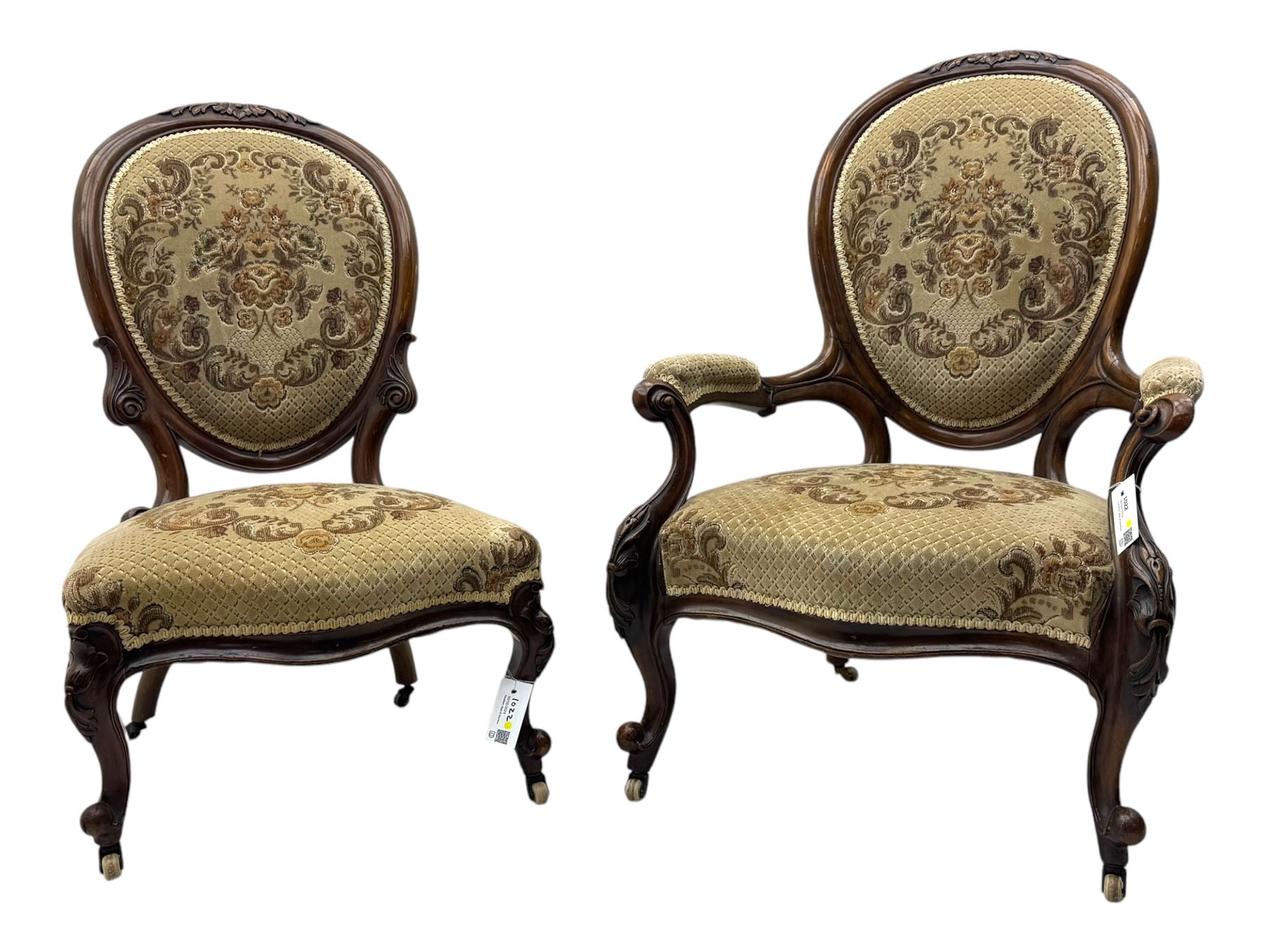 Pair of Victorian walnut lady's and gentleman's drawing room chairs, arched cresting rail carved with cartouche and extending foliage, upholstered in floral pattern fabric, on foliate carved cabriole feet