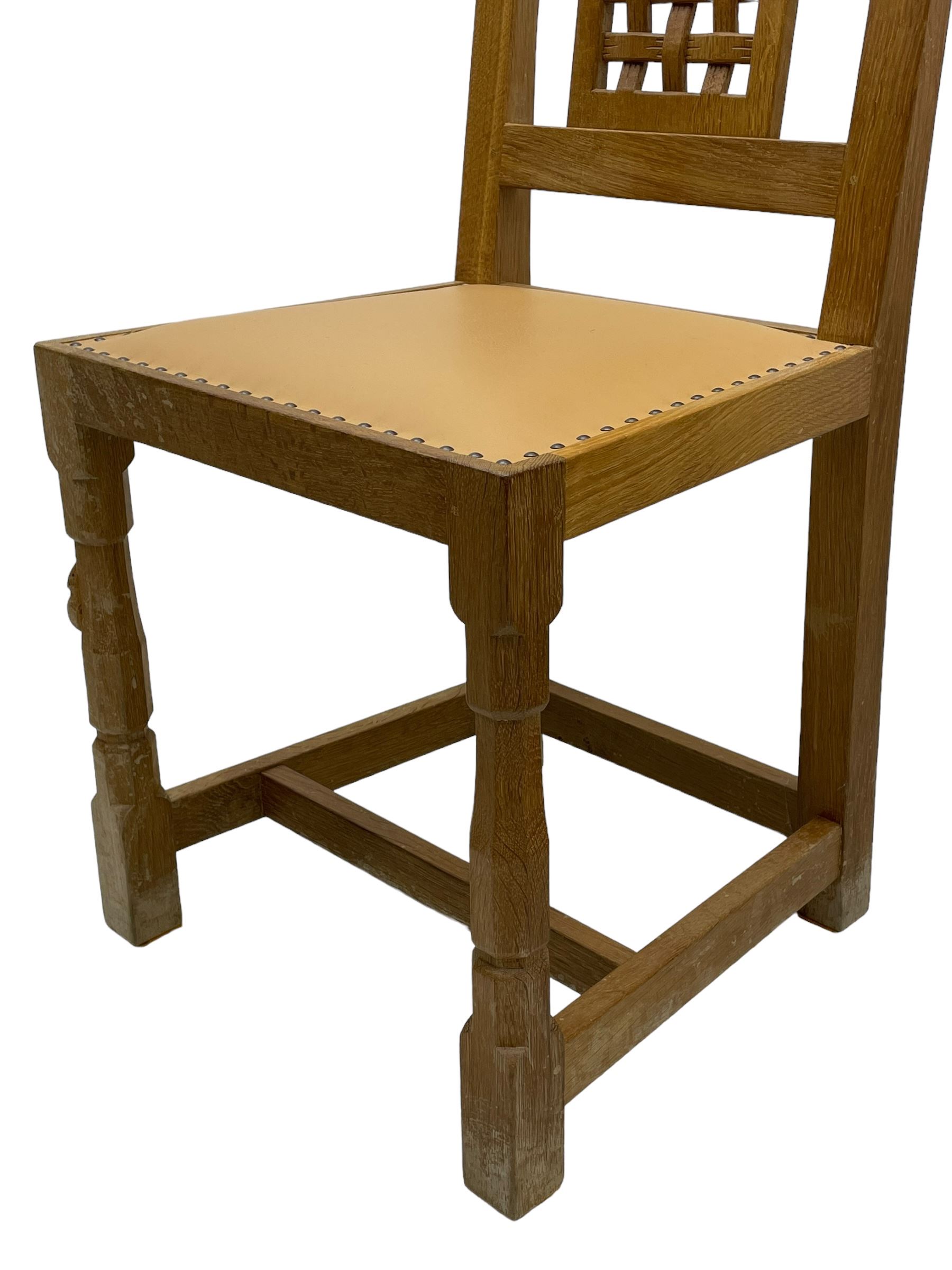 Mouseman - set of six oak dining chairs, pierced and carved lattice panel back over tan leather seat with studded band, on octagonal front supports united by plain H stretchers, carved with mouse signature, by the workshop of Robert Thompson, Kilburn 