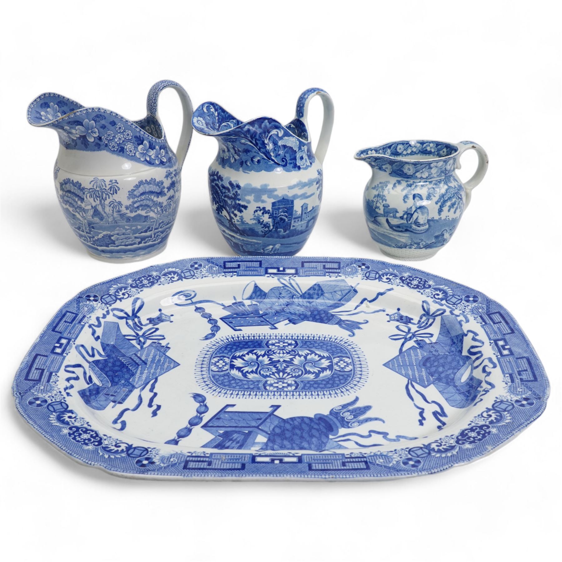 Three 19th century blue and white transfer printed jugs, two of helmet form, the other with basket weave moulded base, together with a 19th century blue and white meat plate, L52.5cm (4)