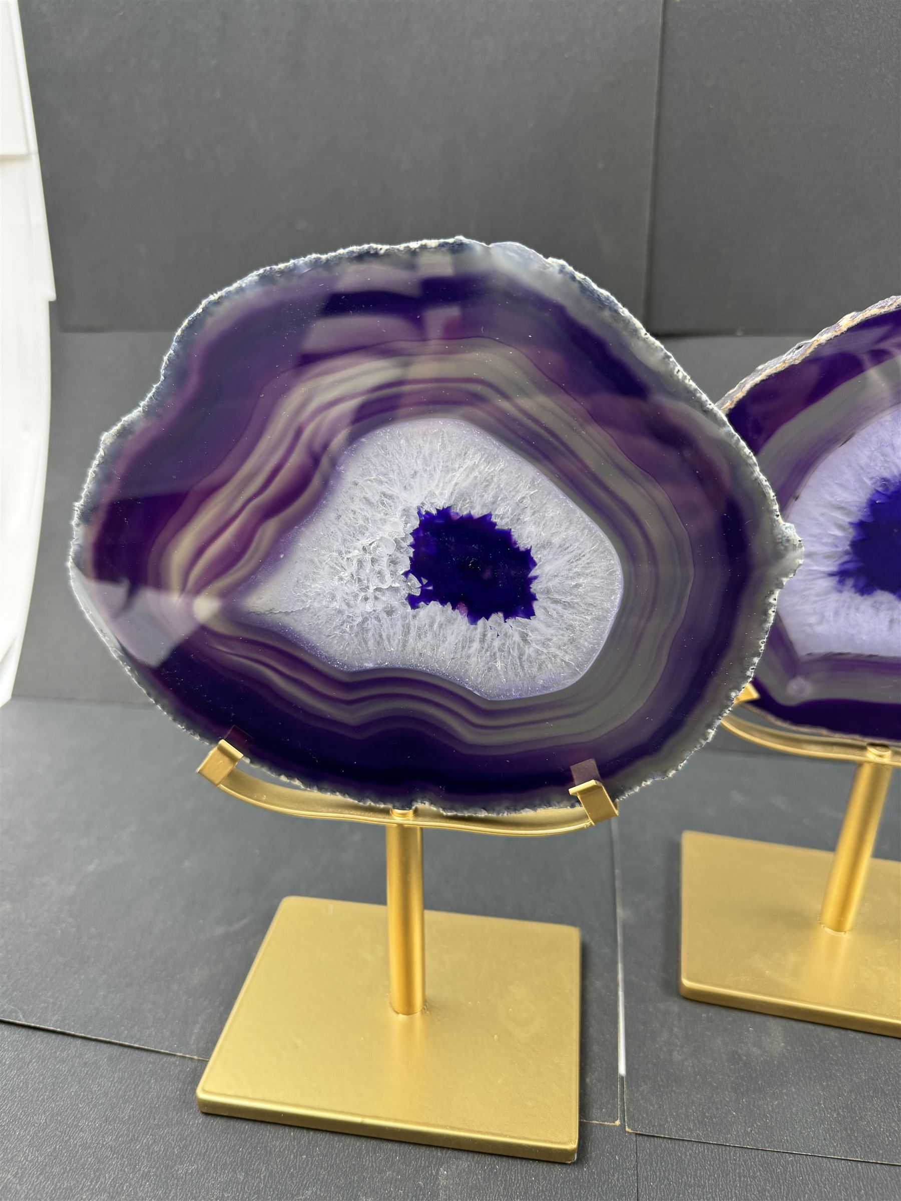 Pair of purple agate slices, polished with rough edges, raised upon gilt metal stands, H22cm